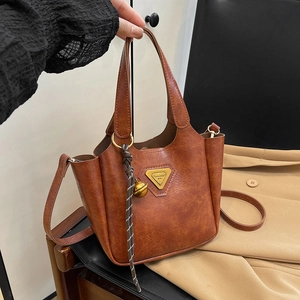 Vintage brown PU leather bucket bag with metal logo and woven bell charm accessory