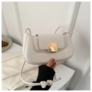 Détail du sac beige avec boucle dorée carrée et bandoulière à nœuds élégante