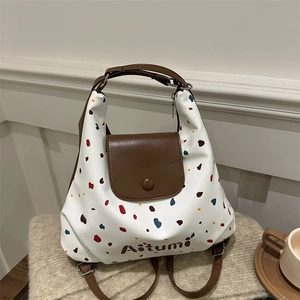 Borsa tote a pois con patta in pelle marrone su sfondo accogliente in feltro beige