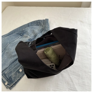 Interior view of black canvas tote showing large capacity with daily essentials and magnetic snap