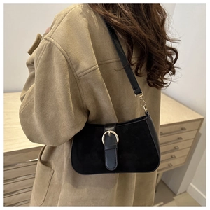 Close-up of black retro underarm bag featuring matte texture and golden ring buckle detail
