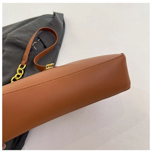 Detailaufnahme der braunen PU-Ledertasche mit feiner Naht und goldener Metallschnalle