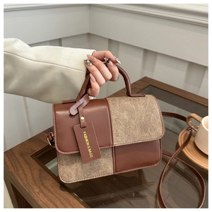 Detail of the stitching and dual-tone synthetic leather of the crossbody bag