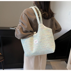 Dettaglio della borsa tote in maglia arcobaleno con texture morbida e logo in tessuto