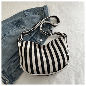 Close-up of black and white striped canvas hobo bag with twill weave texture
