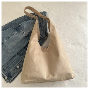 Macro view of matte beige suede tote bag texture with minimalist seamless stitching