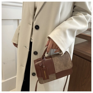Detail of color-block crossbody bag with brown leather and suede texture contrast