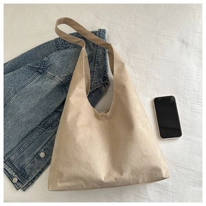 Top view of beige matte suede tote bag styled with denim jacket and mobile phone