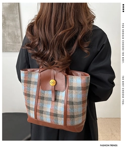 Detail of color-block striped tweed tote bag with leather straps and metal buckle