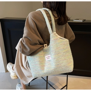 Borsa tote in maglia a righe arcobaleno con etichetta indossata a spalla da una modella