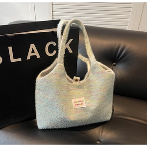 Dettaglio di una borsa in maglia arcobaleno con etichetta del marchio su tessuto soffice
