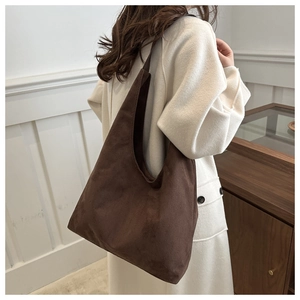 Close-up of deep brown matte suede tote bag with integrated shoulder strap design