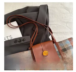 Detail of tweed checkered tote bag with leather trim and golden metal round buckle