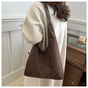 Detail of dark brown hobo bag showing high-quality matte suede texture and wide shoulder strap