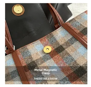 Close-up of golden magnetic snap button on plaid fabric tote bag with leather trim