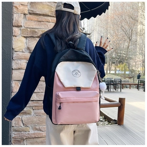 Detail of pink and black color-block nylon backpack with plush ball and XUEFENG logo
