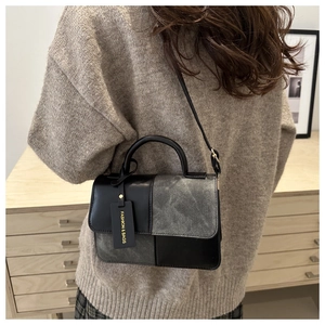 Detailed back view of a patchwork crossbody bag with black and grey leather finish