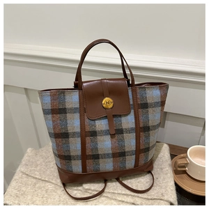 Detail of striped knit tote bag with premium brown leather trim and golden metal N buckle