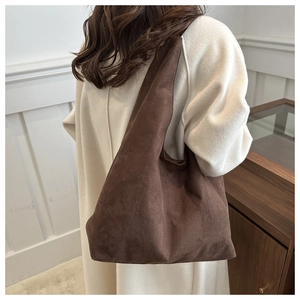 Deep brown matte suede tote bag shown on a model wearing a beige coat for daily commute