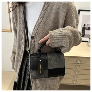 Detail of the chic contrast stitching and 'FASHION & BAGS' tag on the small square handbag