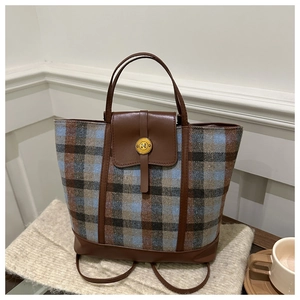 Dettaglio della borsa tote a righe con texture in tweed e fibbia dorata a forma di N
