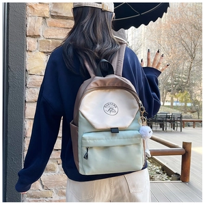 Outdoor shot showing back view of color-block backpack with adjustable straps and side pocket