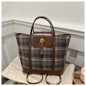 Dettaglio della borsa tote a righe con finiture in pelle marrone e fibbia dorata logo N