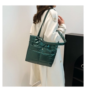 Deep green quilted tote bag shown on model with beige trench coat for a stylish look