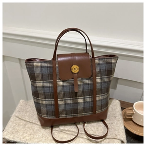 Macro view of plaid wool fabric and brown leather handle on a vintage backpack