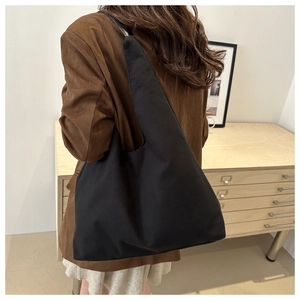 Hobo style black matte shoulder bag shown on model for size and drape perspective