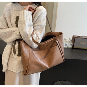 Detail of vintage brown tote bag with lychee texture and spacious front pocket