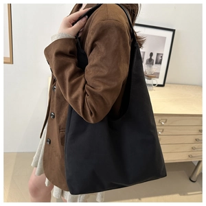 Detailed view of a black high-capacity tote bag worn on shoulder for commuting style