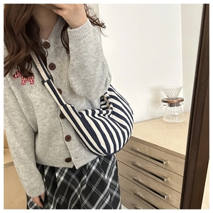 Selfie miroir montrant le sac en toile à rayures bleues et blanches porté par un mannequin