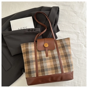 Dettaglio della borsa tote vintage con patchwork scozzese e patta in pelle elegante