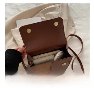 Detailed internal view of brown leather crossbody bag showing storage capacity and suede flap