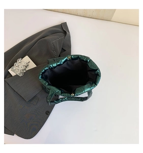 Detailed interior of dark green puffer tote showing magnetic clasp and quilted texture