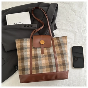 Dettaglio della borsa tote in lana a quadri con patta in pelle marrone e logo N in metallo