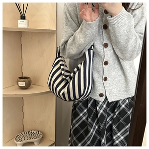 Detailed close-up of blue and white striped canvas hobo bag with a knit texture finish
