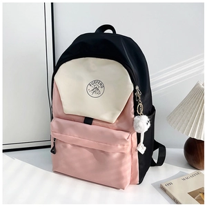 Detail view of water-resistant nylon backpack with three-color stitching and plush pendant