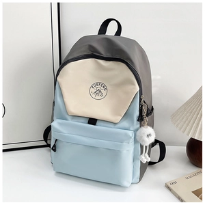 Close-up of color-block backpack with XUEFENG logo and white plush monster charm