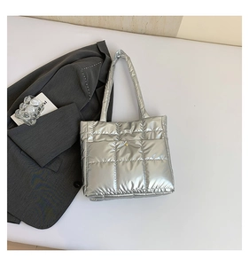 Detail of silver metallic quilted tote bag with large square stitching and metal closure