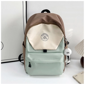 Close-up of tricolor block backpack with mountain logo and plush charm accessory