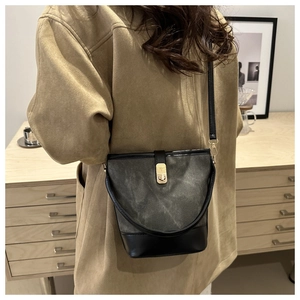 Detail of vintage bucket bag featuring distressed texture and gold rectangular lock