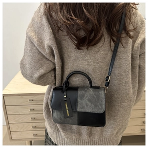 Detailed view of the stylish mixed-material crossbody bag with custom letter pendant tag