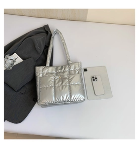 Close-up of metallic silver quilted tote bag with puffy texture and shoulder strap