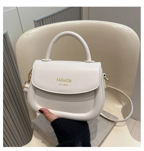 Detail of white leather saddle bag showing adjustable strap and gold FASHION logo