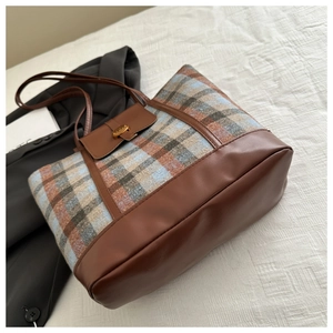 Vista dettagliata del tessuto a quadri e pelle marrone su borsa tote elegante