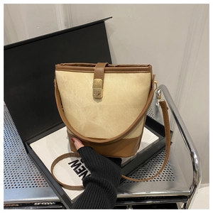 Detail of vintage canvas bucket bag with brown leather trim and gold twist lock closure