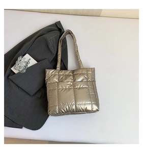 Detailed view of the metallic champagne quilted tote bag with magnetic closure