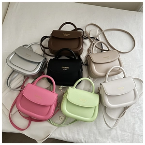 Collection de sacs selle minimalistes en sept couleurs avec logo sur surface texturée